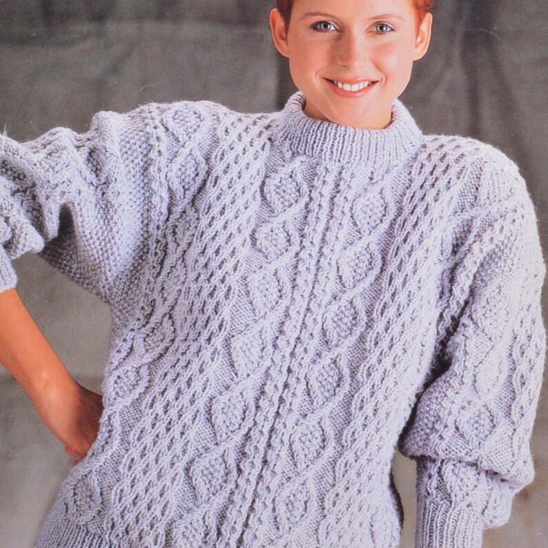 May include: A light purple knitted sweater with a cable knit pattern.