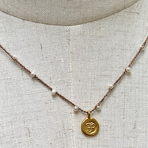 Silk cord thread crocheted pearls with Om gold charm necklace