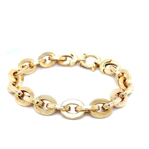May include: A gold-colored bracelet featuring a series of interconnected, circular links. The bracelet has a polished finish and a secure clasp. The design is simple yet elegant, suitable for everyday wear or special occasions.