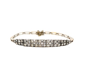 May include: A silver and gold bracelet with a row of square-shaped diamond clusters.