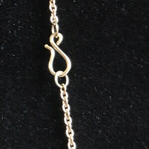 May include: A gold chain necklace with a lobster clasp closure.