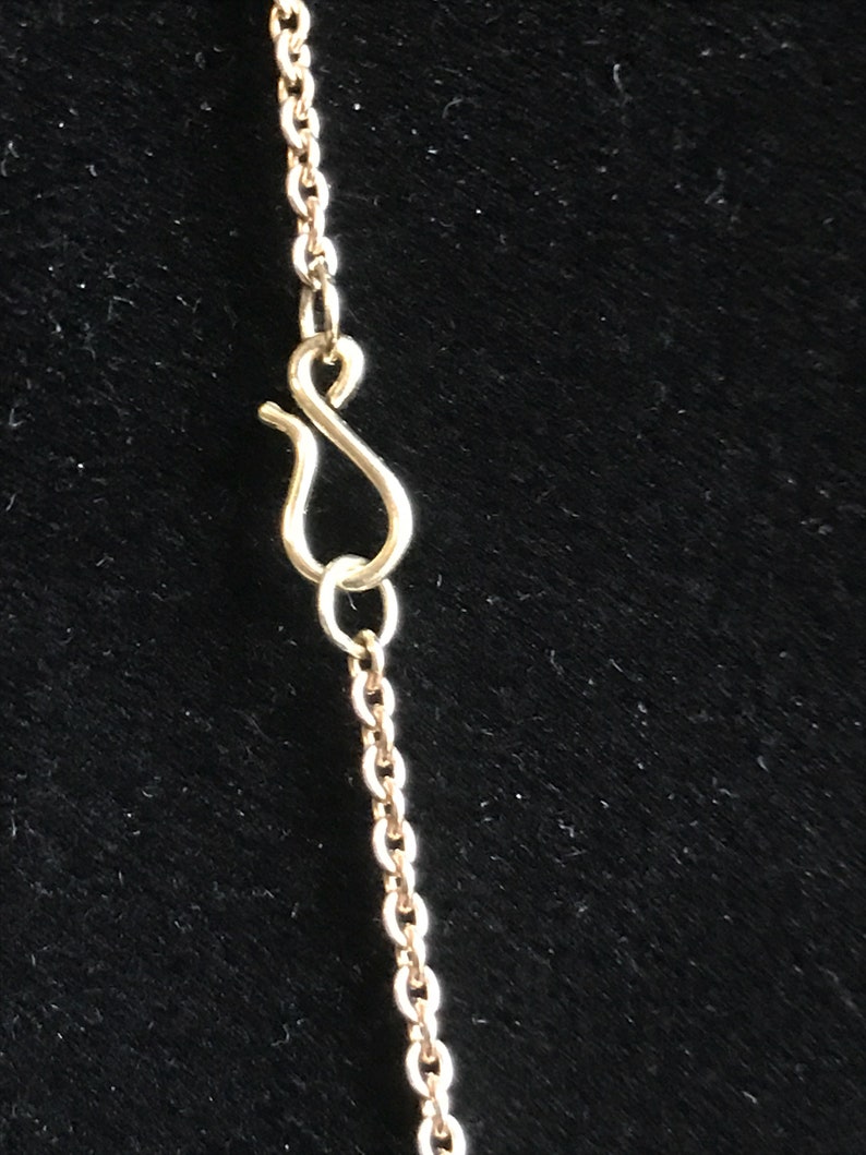 May include: A gold chain necklace with a lobster clasp closure.