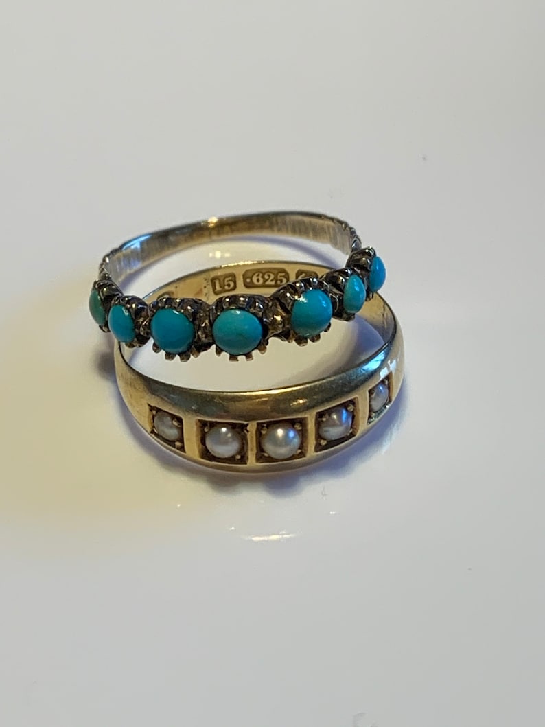 May include: Two gold rings, one with turquoise stones and the other with pearls. The turquoise ring has the inscription "15 625" on the band.