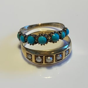 May include: Two gold rings with turquoise and pearl stones. The top ring has a row of turquoise stones set in a gold band. The bottom ring has a row of pearls set in a gold band.