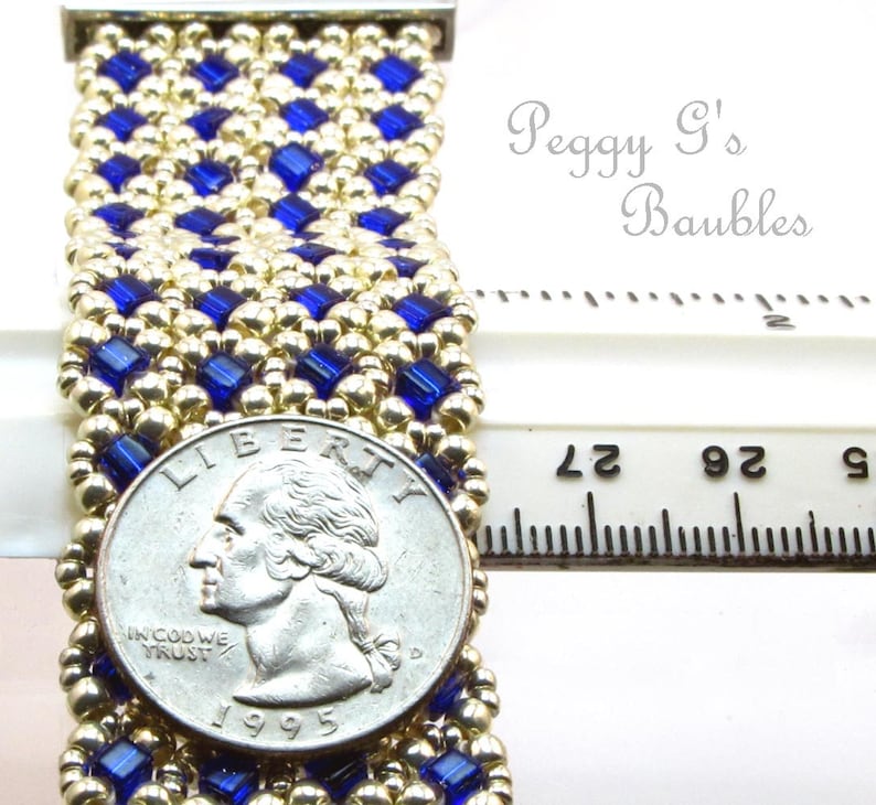 May include: A gold and blue beaded bracelet with a silver quarter for scale. The bracelet is approximately 2 inches wide and is made with small, square beads. The text "Peggy G's Baubles" is visible in the image.