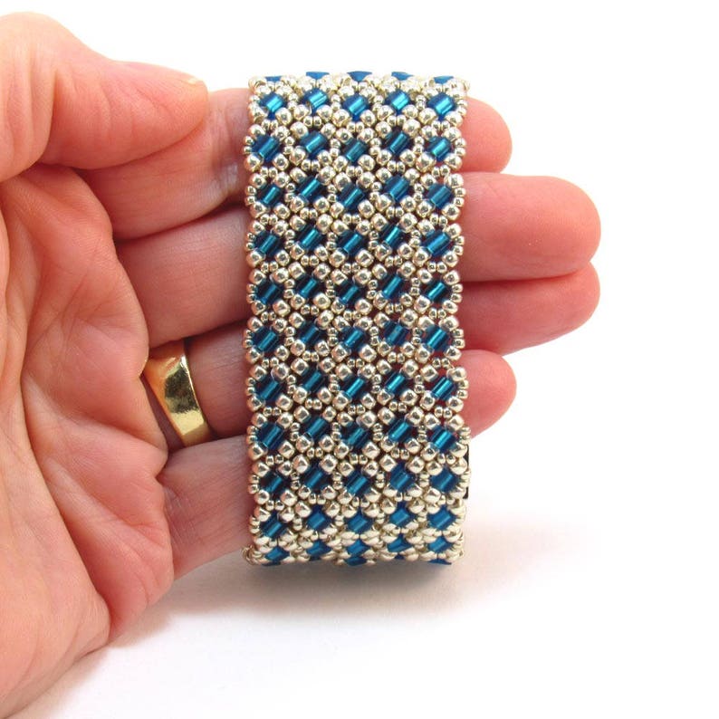 May include: A blue and gold beaded bracelet with a geometric pattern.