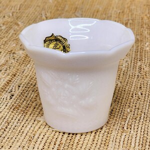 May include: A white ceramic mug with a black handle and the text "But First, Coffee" in a bold, black font. The mug is set against a neutral background, highlighting its simple design. The mug appears to be approximately 4 inches tall.
