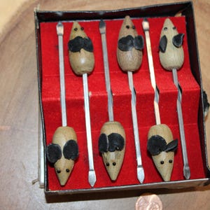 May include: Set of six wooden mouse-shaped cheese spreaders in a black box with a red velvet lining. Each spreader has a black painted face with a small black nose and eyes.