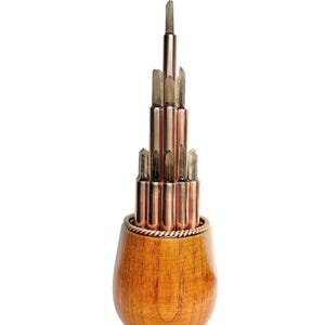 Puede incluir: Objeto decorativo artesanal con base de madera y varillas de cobre rematadas con cristales de cuarzo transparente. Las varillas de cobre están dispuestas en una estructura en forma de torre, con un detalle de alambre de cobre trenzado.