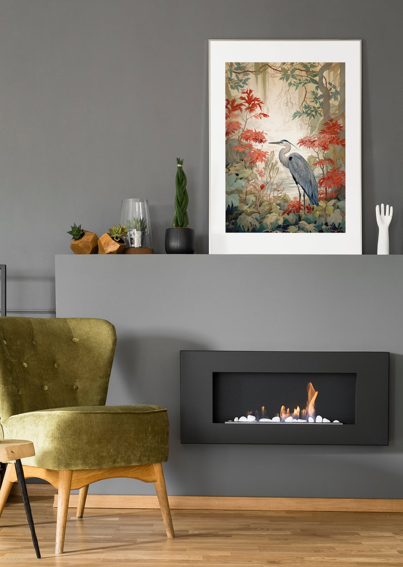 Puede incluir: Una chimenea gris con un marco negro y un fuego ardiendo en su interior. Sobre la chimenea hay una impresi&oacute;n enmarcada de una garza azul de pie en un bosque con flores rojas.