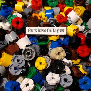 May include: A large assortment of colorful Lego pieces, including gears, wheels, and other building blocks. The pieces are in various colors, including red, blue, green, yellow, and brown.