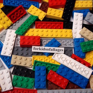 May include: A large collection of colorful Lego bricks in various sizes and shapes. The bricks are mostly in shades of red, blue, yellow, green, and gray. The text "forkidsofallages" is visible on a white label.