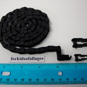 May include: Black plastic chain with two black plastic connectors. The chain is coiled and measures approximately 6 inches long. The connectors are about 1 inch long.