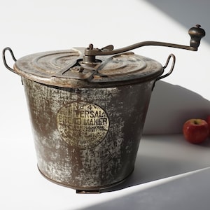May include: Vintage No. 4 Universal Bread Maker with a hand crank and a metal container. The container has a label that reads "No. 4 Universal Bread Maker" with a gold medal design.
