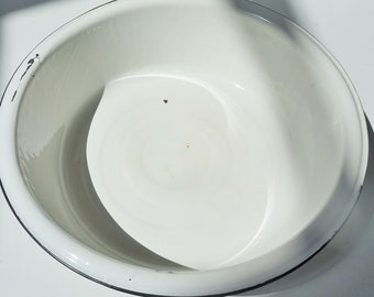 May include: White enamel basin with a black rim. The basin is round and has a smooth, white surface.