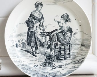 May include: Black and white illustration of two women on a plate. One woman is sitting on a stool and holding a pipe. The other woman is standing and holding a basket. The illustration is on a white background.