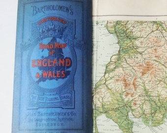 May include: An open vintage road map of England and Wales. The blue cover displays the title in red and white lettering, with the words "Bartholomew's Contoured Road Map of England & Wales". The map shows detailed geographical information and road networks.