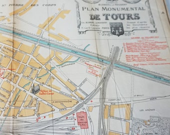May include: A vintage map of Tours, France, with a title that reads "Plan Monumental de Tours." The map shows the city's streets, buildings, and landmarks, including the Church of the Sacred Heart, the railway station, and the Chateau de Beaujardin. The map is printed in black and white with red and blue accents.