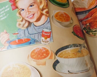 May include: A vintage cookbook with a colorful illustration of a young woman holding a bowl of tomato soup. The cookbook features a variety of recipes, including soup, chicken, and other dishes. The text on the cover reads "Soup's my and now have it times!"