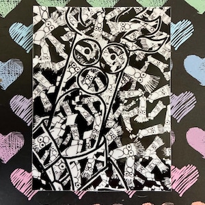 May include: A black and white art print featuring a repeating pattern of cartoon characters. The print has a glossy finish and is rectangular. The background is black with colorful, sketched hearts.