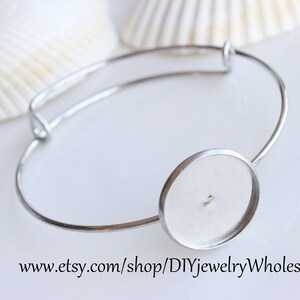 May include: Silver bangle bracelet with a round, clear glass cabochon setting. The bracelet is open and adjustable. www.etsy.com/shop/DIYjewelryWholesale
