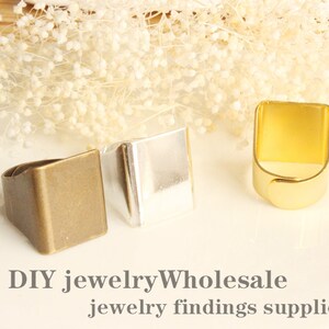 Op de afbeelding: Drie blanco metalen ringbases in goud, zilver en brons. De bases zijn rechthoekig en hebben een gladde afwerking. DIY sieraden groothandel sieraden benodigdheden.