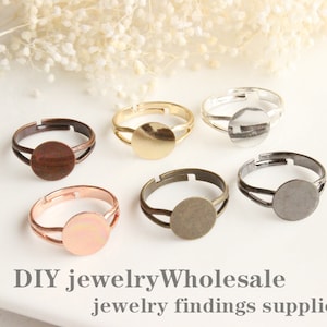 Op de afbeelding: Zes verstelbare ringblanken in verschillende metaalafwerkingen: goud, zilver, koper, brons en zwart. Elke ringblank heeft een ronde bezel om een cabochon of andere versiering toe te voegen. DIY-sieradenbevindingen.