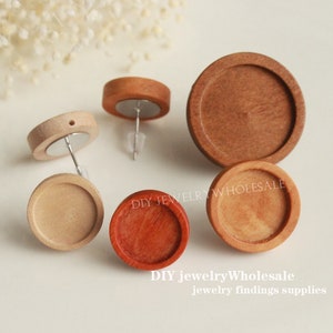 Könnte beinhalten: Vier runde Holzrohlinge für Ohrringe in verschiedenen Brauntönen. Die Rohlinge sind rund und haben eine glatte Oberfläche. DIY jewelryWholesale Schmuckzubehör.