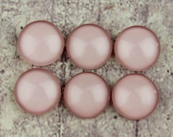 Könnte beinhalten: Sechs runde, blassrosa Glascabochons. Diese Cabochons sind glatt und haben eine leicht irisierende Oberfläche. Sie sind perfekt für die Schmuckherstellung.