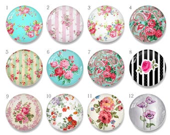Puede incluir: Una colección de doce cabujones redondos de vidrio con diseños florales. Los cabujones presentan varios patrones, incluyendo rosas, rayas y cachemir, en colores como rosa, azul y blanco. Estas piezas decorativas de vidrio son adecuadas para la fabricación de joyas o proyectos de artesanía.