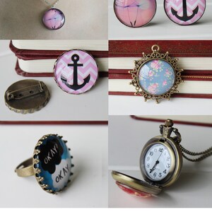 May include: Assortment of glass cabochons with various designs, including an anchor, flowers, and a cloud with the text "OKAY? OKAY". The cabochons are set in different metal settings, including a necklace, a ring, a brooch, and a pocket watch.
