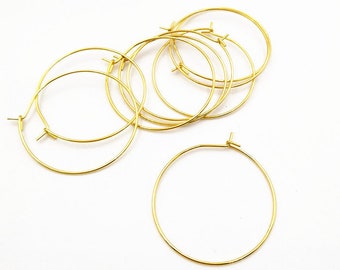 May include: A set of six gold-toned hoop earrings. The hoops are simple and circular, with a smooth finish.
