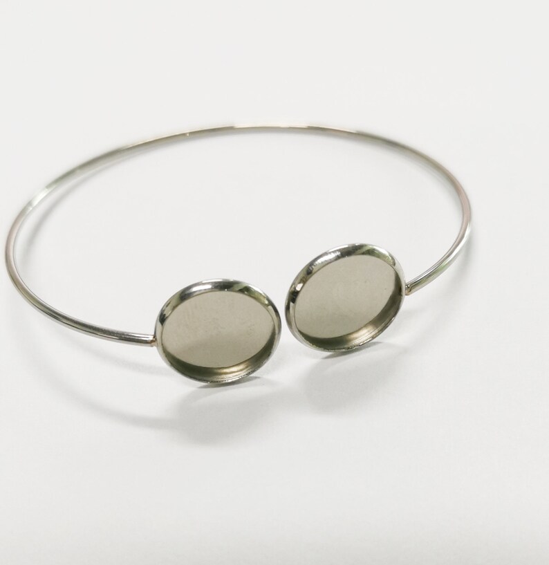 May include: Silver bangle bracelet with two round, clear glass cabochons.