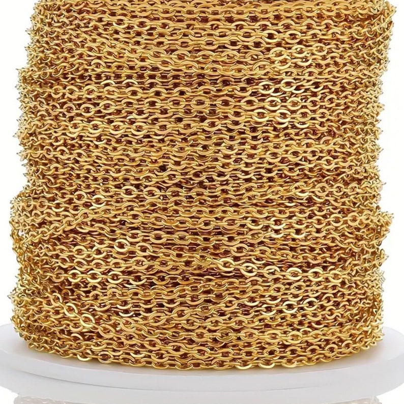 May include: A spool of gold-colored chain, perfect for jewelry making. The chain is made of small, linked oval shapes.