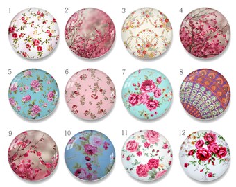 Puede incluir: Una colección de doce cabujones redondos de vidrio con varios diseños florales y estampados. Los diseños incluyen rosas, flores de cerezo y estampados de cachemira en tonos rosa, azul y morado. Estas piezas decorativas de vidrio son adecuadas para la fabricación de joyas o manualidades.