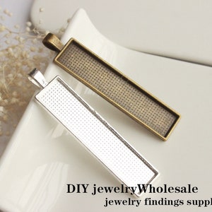 May include: Two rectangular metal pendant trays, one silver and one bronze, with a textured surface.  DIY jewelry Wholesale jewelry findings supplies.