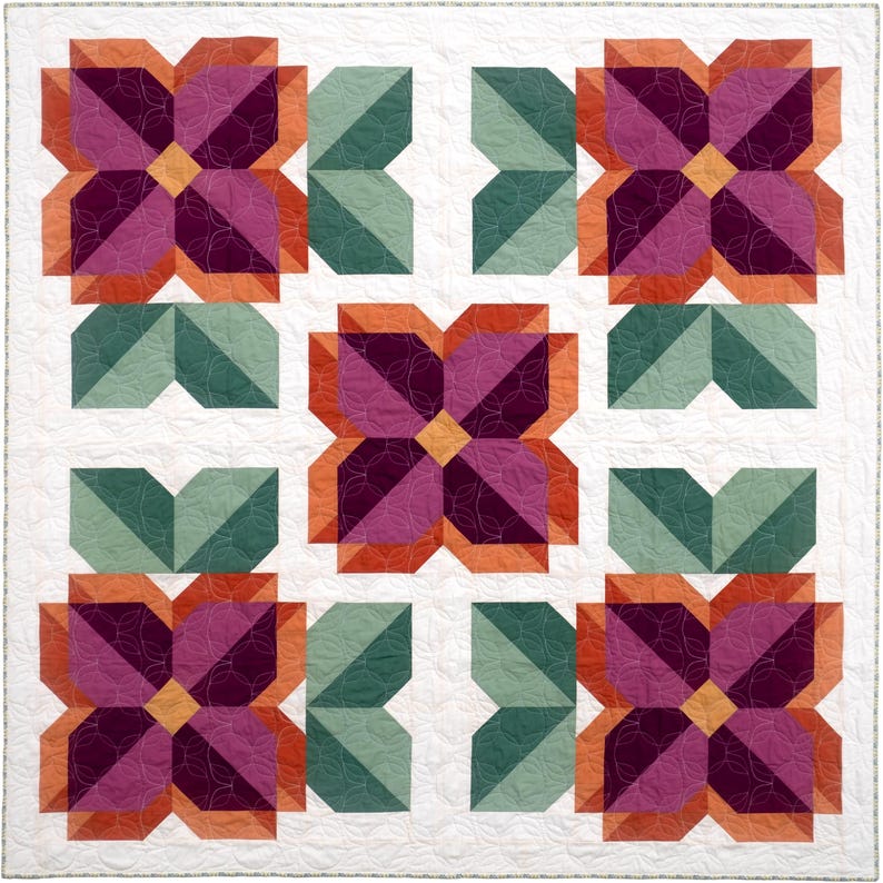 May include: A square quilt featuring five floral blocks arranged in a grid pattern. Each flower consists of deep purple and magenta petals with orange accents, surrounded by sage green leaves, all set against a white background with circular quilting.