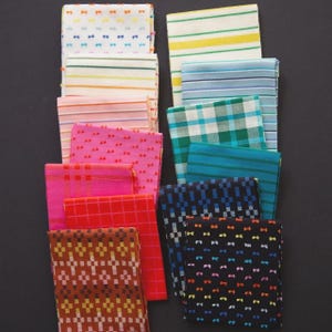 May include: A collection of folded fabric squares in various patterns and colors. Designs include stripes, plaid, and repeating bow tie motifs. Colors range from pink and red to blue and brown, with some squares featuring multiple colors.