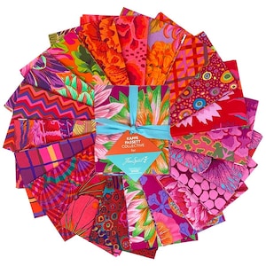 May include: A collection of colorful fabric squares arranged in a circular pattern. The fabrics feature vibrant floral and abstract designs in shades of pink, orange, red, and purple. A teal ribbon ties the bundle together, with a tag that reads "Kaffe Fassett Collective for FreeSpirit."