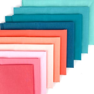 May include: A stack of ten fabric squares in shades of teal, blue, coral, peach, and pink. The fabric is smooth and has a subtle sheen.
