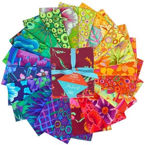 May include: A collection of colorful fabric squares arranged in a circular pattern. The fabrics feature vibrant floral and abstract designs in shades of green, blue, purple, orange, and red. A bundle of maroon fabric is tied with a teal ribbon and a tag that reads "Kaffe Fassett Collective".