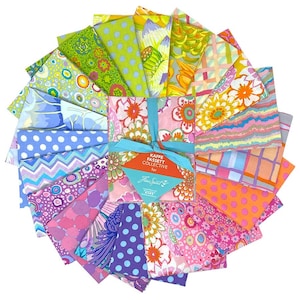 May include: A collection of folded fabric squares arranged in a circular fan pattern, featuring diverse floral, polka dot, chevron, and abstract prints in vibrant colors. A teal ribbon ties the center, holding a tag labeled Kaffe Fassett Collective.