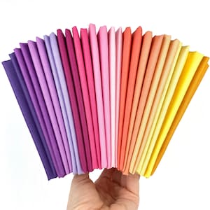 May include: A fan of 20 fabric swatches in a gradient of colors from purple to yellow. The swatches are arranged in a semi-circle, with the purple swatches on the left and the yellow swatches on the right.