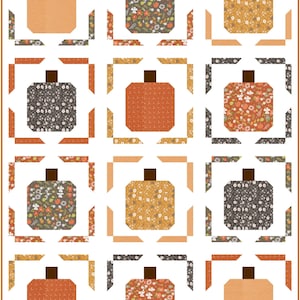 May include: A quilt featuring a grid of twelve pumpkin blocks on a white background. Each pumpkin has a brown stem and is framed by four corner pieces in various autumn-themed patterns, including floral prints, dots, and solid orange shades.