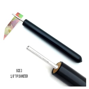 Paper Bead Roller Quilling Tool with 1/8 inch diameter Slotted Tip and black vinyl covered handle. Paper roller has strip of paper in tip.