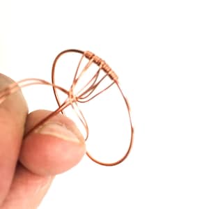 May include: A copper wire ring with multiple wire loops extending from the top, forming a circular shape.