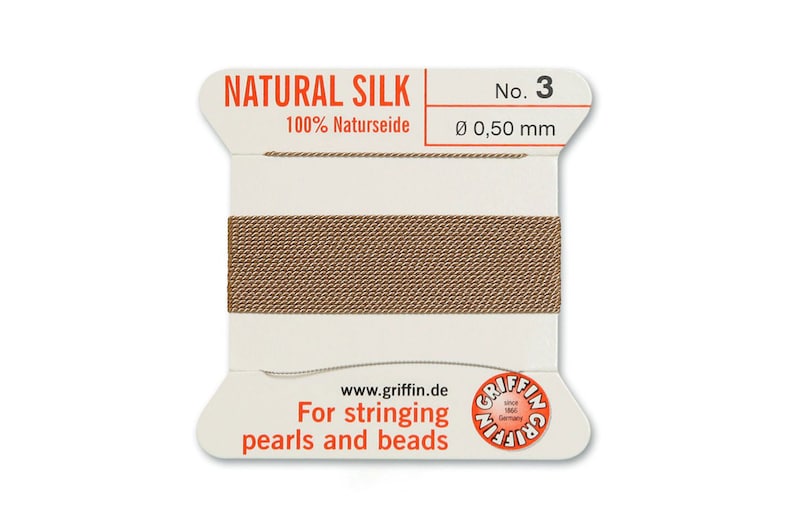 May include: A spool of natural silk thread for stringing pearls and beads. The spool is labelled "Natural Silk 100% Naturseide No. 3 &Oslash; 0,50 mm" and "www.griffin.de For stringing pearls and beads".