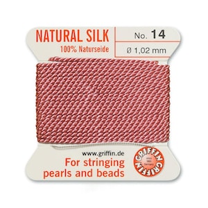 Puede incluir: Una bobina de hilo de seda natural para enhebrar perlas y cuentas. El hilo es rosa y est&aacute; etiquetado con "NATURAL SILK 100% Naturseide No. 14 &Oslash; 1,02 mm".