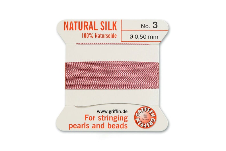 May include: A spool of natural silk thread for stringing pearls and beads. The spool is labelled "NATURAL SILK" and "100% Naturseide". The thread is a light pink colour and is 0.50 mm in diameter.