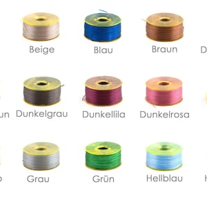 Op de afbeelding: Een verzameling van 15 spoelen garen in verschillende kleuren, waaronder abrikoos, beige, blauw, bruin, donkerblauw, donkerbruin, donkergrijs, donkerpaars, donkerroze, geel, goud, grijs, groen, lichtblauw en lichtbruin.